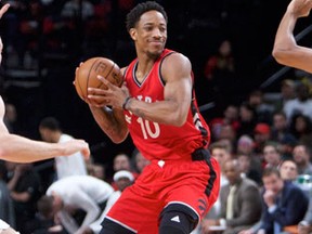 Toronto Raptors guard DeMar DeRozan looks to pass around Portland Trail Blazers centre Mason Plumlee and guard Allen Crabbe during NBA action on Dec. 26, 2016. (AP Photo/Craig Mitchelldyer)