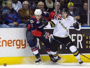Windsor Spitfires defenseman Patrick Sanvido keeps London Knights forward Chandler Yakimowicz from a loose puck during their OHL junior hockey regular season game at Budweiser Gardens in London, Ontario on Sunday December 28, 2014.  Windsor won the game 5-4 in a shootout. CRAIG GLOVER/The London Free Press/QMI Agency