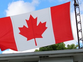 Kevin Aikenhead, 26, displays his special Canadian flag, while standing on the roof his Chatham, Ont. home, that flew from the Peace Tower on Parliament Hill on Aug. 21, 2015. He received the flag last September, more than 11 years after requesting it. Aikenhead waited until this Canada Day weekend to fly it, with the first time being atop a wind turbine on Thursday, June 30, 2016 along Highway 401 near the Bloomfield Road overpass, just outside Chatham, Ont.