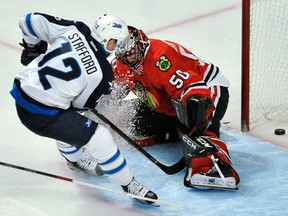 Winnipeg Jets' Drew Stafford scores a goal against Chicago Blackhawks goalie Corey Crawford during the third period of Thursday night's game. (AP Photo/Paul Beaty)