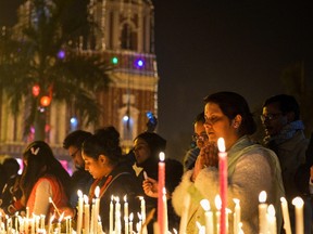Indian people light candles during a Christmas Eve service at the Sacred Heart Cathedral in New Delhi on Dec. 24. (CHANDAN KHANNACHANDAN KHANNA/Getty Images)
