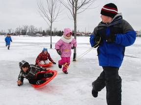 Kaiden Boyce pulls Aiden Skinner on a sled ahead of the girls team of Rachel Roberts, centre, and Olivia Smith at the sled activity station during the Bayridge Public School winter carnival, which saw more than 200 people play in the snow at 11 outdoor activities stations in Kingston, Ont. on Saturday February 27, 2016. Julia McKay/The Whig-Standard/Postmedia Network
