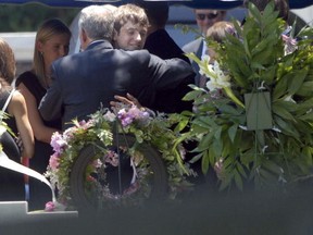 John Ramsey (left) hugs his son, Burke, at the grave of JonBenet Ramsey after a service for his wife, Patsy Ramsey, June 29, 2006 in Marietta, Georgia. (Barry Williams/Getty Images)
