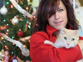 Tim Miller/The Intelligencer
Quinte Humane Society staff member Amy Collins cuddles up to Irish, a domestic-shorthair cat she rescued on her way into work Boxing Day morning. Collins found the cat frozen in the middle of the road early Monday morning.