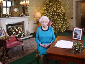 In this photo released early Sunday Dec. 25, 2016, Britain’s Queen Elizabeth II poses for a photo, sitting at a desk in the Regency Room of Buckingham Palace in London, after recording her traditional Christmas Day broadcast to the Commonwealth. (Yui Mok/Pool via AP)