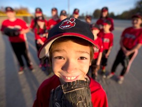 Alvinston Indians player Michael MacKeller, 9, shows off the Chief Wahoo logo on his ball cap while surrounded by teammates on their home field earlier this fall. Having mulled it over for the past few years, the board of the team has decided to replace the logo and name. Craig Glover/The London Free Press/Postmedia Network