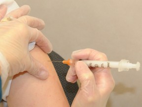 A pharmacist gives a flu shot.
