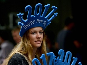 A woman sells "Happy New Year 2017" headwear on a shopping street in Sydney on Friday. (AFP PHOTO/Peter PARKS)