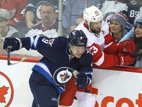 Winnipeg Jets centre Andrew Copp (left) checks Detroit Red Wings defenceman Brian Lashoff during a game earlier this month. Copp was recalled by the Jets on Friday from the Manitoba Moose, two days after demoting him. (Brian Donogh/Winnipeg Sun file photo)