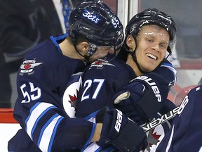 Winnipeg Jets right winger Nikolaj Ehlers (right) is hugged by centre Mark Scheifele earlier this year. (Brian Donogh/Winnipeg Sun file photo)