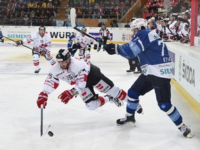 Canada's Dustin Jeffrey, left, fights for the puck against Minsk's Alexander Kitarov, right, during the game between Dinamo Minsk and Team Canada, at the 90th Spengler Cup hockey tournament in Davos, Switzerland, Monday, Dec. 26, 2016. (Melanie Duchene/Keystone via AP)