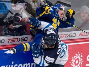 Sweden's Tim Soderlund is checked into the boards by Finland's Eeli Tolvanen during world junior hockey championship action in Montreal on Thursday, Dec. 29, 2016. (Paul Chiasson/The Canadian Press)