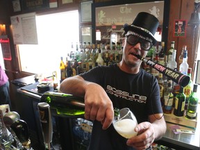 Red Lion Pub bartender, Joe Roberto, pours a glass of champagne to mark the festive weekend.
