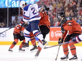 U.S. forward Kieffer Bellows (23) hits Canada forward Mathieu Joseph (11) during first period world junior hockey championship action in Toronto on Saturday, Dec. 31, 2016. (Nathan Denette/The Canadian Press)