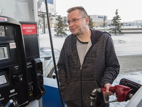 Marty Gillingwater filling his truck with gas on Saturday. Alberta's carbon tax kicks in on Jan. 1 and some  Edmontonians are lining up at the Costco gas pumps in advance to save that 4.5 cents one more time on December 31, 2016.  Photo by Shaughn Butts / Postmedia