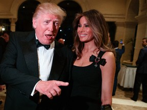 Melania Trump, right, looks on as her husband president-elect Donald Trump talks to reporters during a New Year's Eve party at Mar-a-Lago, Saturday, Dec. 31, 2016, in Palm Beach, Fla. (AP Photo/Evan Vucci)