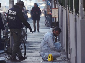 Forensic police collect evidence on the site of the explosion of a bomb in front of a bookstore in Florence, Italy, Sunday, Jan. 1, 2017. A bomb-squad officer was wounded when a suspicious package he was examining exploded. (Maurizio Degl'Innocenti/ANSA via AP)