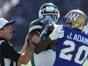 YEAR IN REVIEW: Winnipeg Blue Bombers DB Johnny Adams (right) and  Saskatchewan Roughriders WR Caleb Holley mix it up in front of an official during CFL action at the Banjo Bowl in Winnipeg on Sat., Sept. 10, 2016. Kevin King/Winnipeg Sun/Postmedia Network