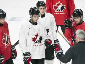 Team Canada captain Dylan Strome and teammates Jake Bean, Mitchell Stephens and Kale Clague listen to head coach Dominique Ducharme during practice ahead of their quarter-final round match against the Czech Republic at the IIHF World Junior hockey Championship in Montreal, Sunday, January 1, 2017. (THE CANADIAN PRESS/Graham Hughes)