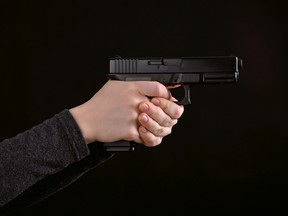 A woman holds a gun in this file photo. (Getty Images)