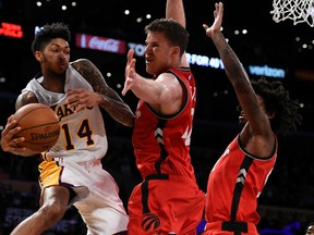 Los Angeles Lakers forward Brandon Ingram passes the ball defended by Toronto Raptors center Jakob Poeltl during the second half of an NBA game in L.A. on Jan. 1, 2017. (AP Photo/Kelvin Kuo)