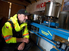 Michael George shows off his biofuel cooker, fuelled with ethanol, as he heats a batch of apple cider in a trailer in London. George says his system produces heat units at about half the cost of electricity. (CRAIG GLOVER, The London Free Press)