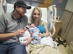 In a Jan. 1, 2017 photo, Brandon Shay, and his wife Holly of Glendale, Ariz., hold their new born twins at at Banner Hospital in Glendale. The couple welcomed their first son, Sawyer, right, into the world at 11:51 p.m. Saturday. Their second son, Everett, arrived one minute after midnight on Sunday. (Nick Oza/The Arizona Republic via AP)