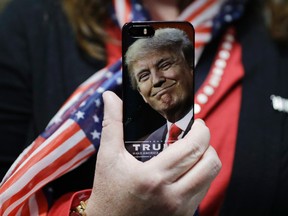 In this Thursday, Sept. 29, 2016, file photo, a woman holds up her cellphone before a rally with then presidential candidate Donald Trump in Bedford, N.H. President-elect Trump tweeted Tuesday that North Korea won’t develop a nuclear weapon capable of reaching parts of the United States, but it’s possible it already has. (AP Photo/John Locher, File)