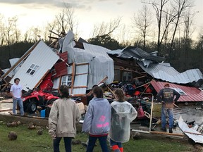 People examine a barn owned by the Miller family that was destroyed during a storm south of Mount Olive, Miss., Monday, Jan. 2, 2017. (Ryan Moore/WDAM-TV via AP)