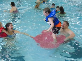 It was all floating fun for the Valley family of Port Elgin  Dec. 30 during a town-sponsored free family swim at Centennial Pool. Pierre Valley helped son Mason balance as mom Jennifer, with two-year-old Chantelle, floated in the shallow end. Frances Learment/Shoreline Beacon