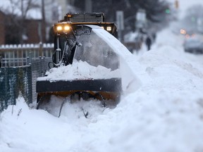 A machine clears snow from the sidewalk on Mountain Avenue. (CHRIS PROCAYLO/WINNIPEG SUN FILE PHOTO)