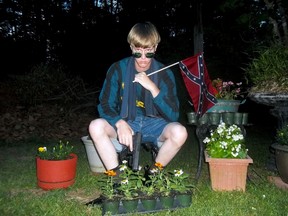 This undated file image that appeared on Lastrhodesian.com, a website being investigated by the FBI in connection with Charleston, S.C., shooting suspect Dylann Roof, shows Roof posing for a photo while holding a Confederate flag and a handgun. (Lastrhodesian.com via AP, File)