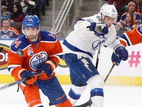 Tampa Bay Lightning's Valtteri Filppula (51) and Edmonton Oilers' Jordan Eberle (14) look for the loose puck during first period NHL action in Edmonton on Dec. 17, 2016.