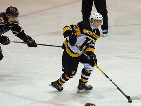 Kingston Frontenacs’ Cal Davis skates with the puck as the Petes’ C.J. Clarke closes in during an Ontario Hockey League game at the Peterborough Memorial Centre on Tuesday night. (Jessica Nyznik/Postmedia Network)