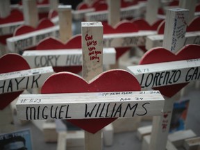 Nearly 800 crosses, each bearing the name of a murder victim, sit on the sidewalk along Michigan Avenue before the start of a march on December 31, 2016 in Chicago, Illinois. Residents, activists and family members of victims of gun violence marched down Michigan Avenue carrying the crosses to draw attention to the city's rising murder rate. Nearly 800 people have been murdered in the city this year and more than 4000 shot as the city copes with its most violent year in two decades. (Photo by Scott Olson/Getty Images)