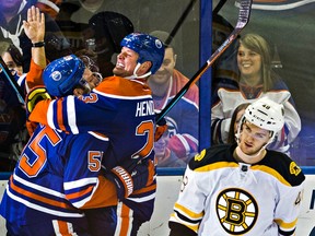 Edmonton Oilers Mark Letestu and Matt Hendricks celebrate a goal as Boston Bruins defenceman Colin Miller skates off the ice at Rexall Place in Edmonton on Dec. 2, 2015. (File)