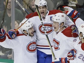 Montreal Canadiens left wing Max Pacioretty jumps to celebrates scoring the game winning goal with teammates Phillip Danault, Michael McCarron and Jeff Petry during overtime of NHL hockey game against the Dallas Stars in Dallas, Wednesday, Jan. 4, 2017. (AP Photo/LM Otero)