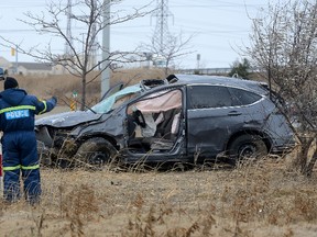 OPP accident reconstruction officers investigate a single vehicle rollover on the off ramp at Highway 401 and Wellington Road that killed a woman and left a man in hospital in critical condition on Wednesday Jan 4, 2017. (MORRIS LAMONT, The London Free Press)