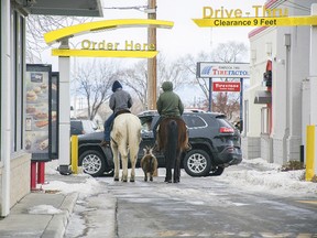 In this photo taken Dec. 30, 2016, Trajen Collins, left, is joined by Joel Perez as they ride their horses through the McDonald's drive-thru with a pet goat in tow in Powell, Wyo. The boys said they were bored during the holiday break and decided to ride their horses to town. The goat just followed, they said. (Toby Bonner/The Powell Tribune via AP)