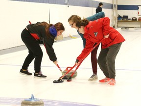 Ecole Secondaire Hanmer skip Jasmine Dumont, right, helps team mates  vice Cierra St. Germain and lead Sophie Menard sweep during high school curling action against the St. Benedict Bears in Sudbury, Ont. on Wednesday December 14, 2016. Gino Donato/Sudbury Star/Postmedia Network