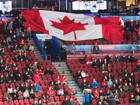 Empty seats are seen as fans pass around a giant Canadian flag before the quarterfinal game between Czech Republic and Canada at the world junior hockey championship in Montreal on Monday, Jan. 2, 2017. (Ryan Remiorz/The Canadian Press)