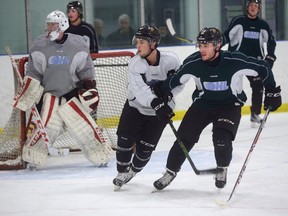 London Knight forwards Owen MacDonald, left, and JJ Piccinich battle in front of goaltender Jordan Kooy during practice at the Western Fair Sports Centre. (MORRIS LAMONT, The London Free Press)