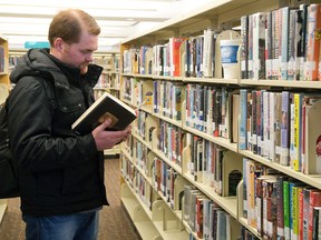 Alex Young looks for novel to read at the London Public Library?s central branch. The library will have to dip into reserves to cover a budget shortfall last year caused by a power outage at the central library and ?unanticipated legal expenses.? (Derek Ruttan/The London Free Press)