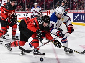 Canada’s Anthony Cirelli and Colin White of Team USA chase the puck during the gold-medal game last night in Montreal. (Getty Images)