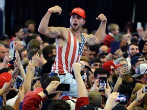 In this April 15, 2016, file photo, a Donald Trump supporter flexes his muscles with the words ‘Build The Wall’ written on them as Trump speaks at a campaign rally in Plattsburgh, N.Y. (AP Photo/Elise Amendola, File)