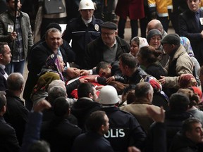 Family members mourn over the coffin of police officer Fethi Sekin, who was killed in a car bomb attack Thursday, during his funeral in the Aegean city of Izmir, Turkey, Friday, Jan. 6, 2017. (AP Photo/Emre Tazegul)
