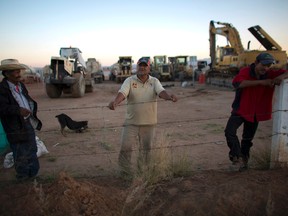 Security guard Jose Guadalupe Gonzalez, left, and other guards watch over the remaining heavy machinery at the Ford construction site with other guards, one day after Ford cancelled plans to build a plant in Villa de Reyes, outside San Luis Potosi, Mexico, Wednesday, Jan. 4, 2017. The long-awaited plant promised 2,800 direct jobs and more than 10,000 indirect ones through Ford's supply chain. (AP Photo/Rebecca Blackwell)
