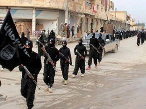 ISIS fighters march in Raqqa, Syria.