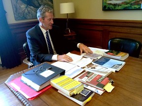 Premier Brian Pallister displayed some of the reports and other documents he says he carried with him on a holiday trip to his vacation home in Costa Rica, at his office in Winnipeg last week. Pallister says he gets a lot of work done while at his vacation home, despite not using email. (THE CANADIAN PRESS/Steve Lambert)