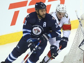 Winnipeg Jets defenceman Dustin Byfuglien (left) and Florida Panthers centre Nick Bjugstad fight for the puck during a game last month. (Brian Donogh/Winnipeg Sun file photo)